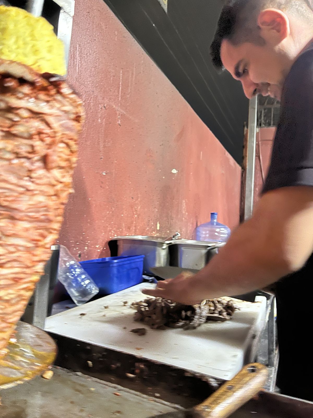 Taquero cortando pastor del trompo